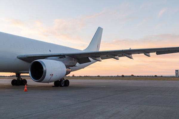 Passenger airplane parked on airport apron at sunset