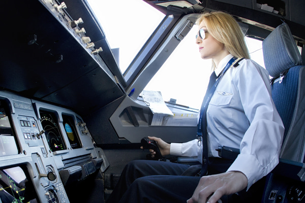 Pilot with uniform seated in an aircraft cockpit