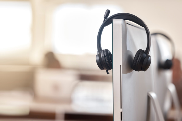 Headset with a microphone hanging over the side of a computer monitor