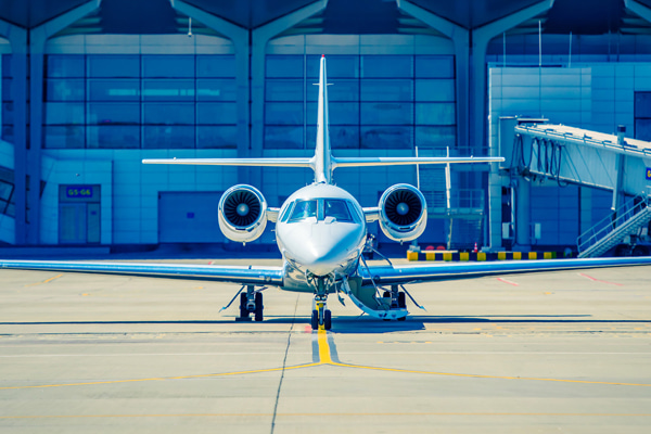 Private jet parked on an airport with a building in the background