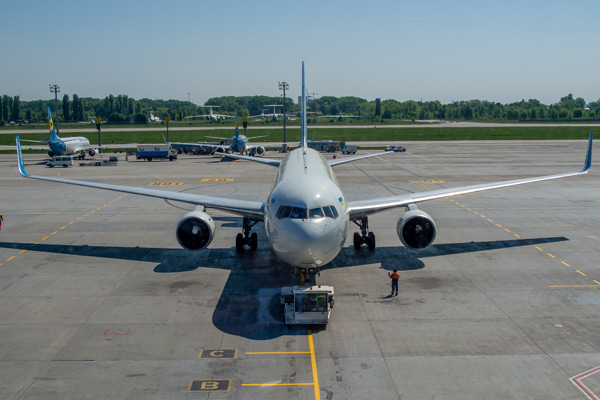 Airplane parked on an airport with a pushback tug in front