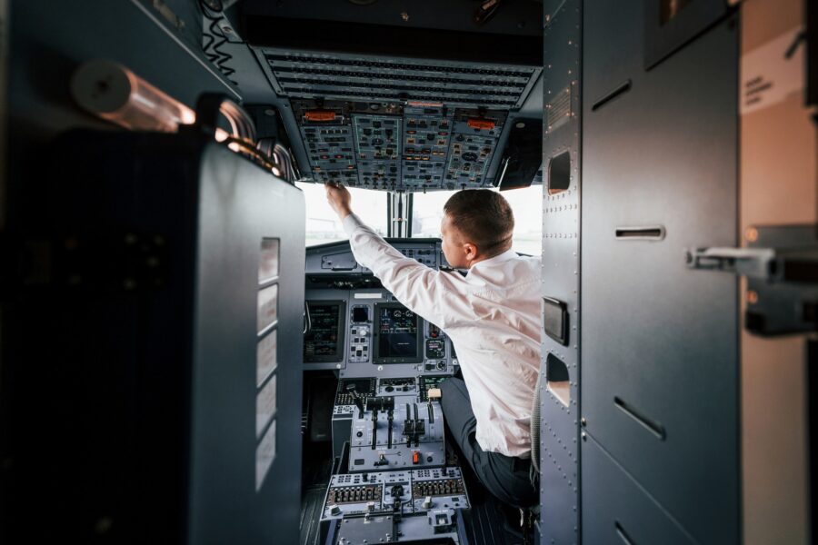 Pilot operating aircraft cockpit controls
