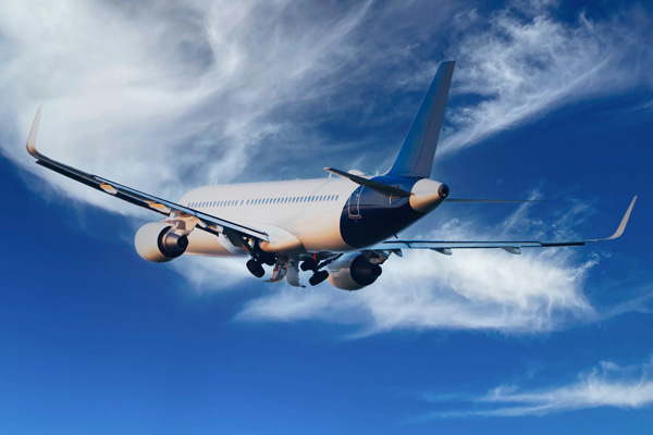 Passenger airliner in flight against a cloudy blue sky