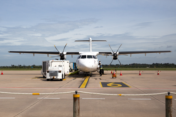 Aircraft parked on an airport with service vehicles nearby