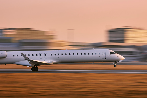 Jet on an airport runway during sunrise