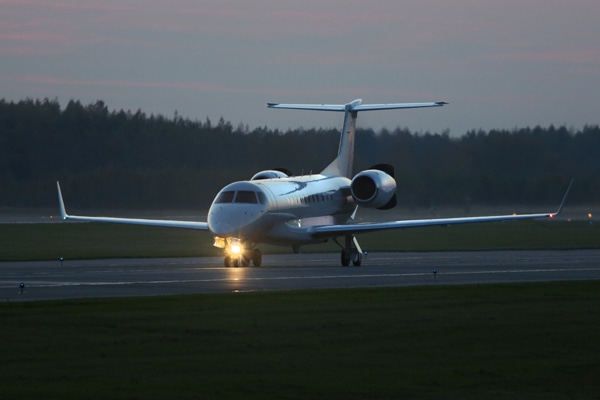 Aircraft on a runway during early night with landing lights