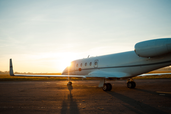 Private jet parked on an airport during sunset
