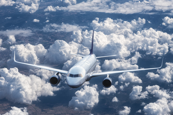 Passenger airplane flying above a thick layer of clouds