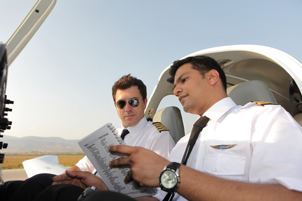 Two persons with pilot uniforms sitting in the cockpit