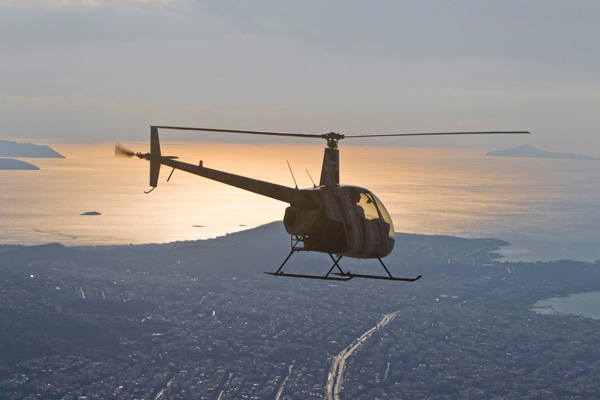 Helicopter flying over an urban landscape at sunset